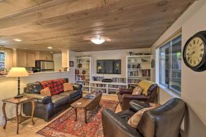 sala de estar con muebles de cuero y reloj en la pared en Secluded Cottage on 2 and Acres with Pond, Dock and BBQ, en Grass Valley