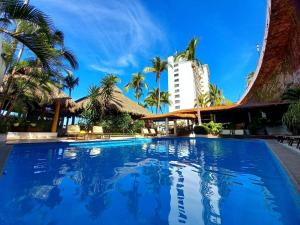 a large swimming pool with a hotel in the background at Costa Sur All Inclusive Resort in Puerto Vallarta