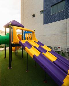 a playground with a slide in front of a building at SALINAS RESORT - Apartamento VISTA MAR in Salinópolis