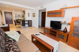 een woonkamer met een bank en een tv bij Apartament PARAISO DEL SOL in Torrevieja