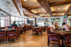 a group of people sitting at tables in a restaurant at Hotel Parque Satelite in Mexico City