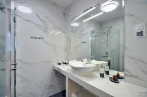 a white bathroom with a sink and a shower at Apartament Królewski in Karpacz