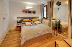 1 Schlafzimmer mit 2 Betten und gelben Kissen in der Unterkunft Apartament Królewski w centrum in Karpacz
