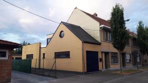 a yellow house with a gambrel roof at Vertentenhuis in Hamme