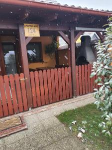 a wooden fence in front of a building with a bell at Terme Čatež Apartma Nine in Čatež ob Savi