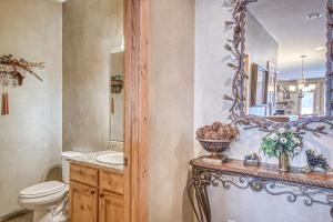 a bathroom with a toilet and a mirror and a sink at Rio Grand Golf Course Home in South Fork +21 photos