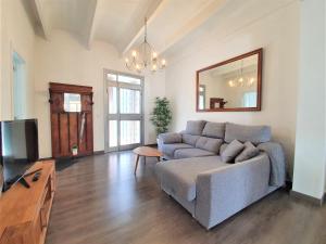 a living room with a couch and a mirror at Casa cercana a Santa Catalina in Palma de Mallorca