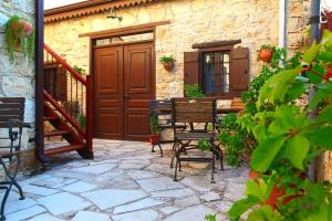 une terrasse avec une table et des chaises devant un bâtiment dans l'établissement Agrovino Lofou, à Lófou