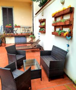 patio con sillas y mesas de mimbre y balcón en Il Sorriso, en Florencia