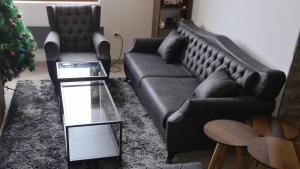a living room with a black couch and a christmas tree at Zlatar Apartman br 16 in Brdo