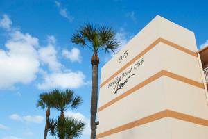 una palmera frente a un edificio en Paradise Beach Club - Oceanfront and Penthouse en Satellite Beach