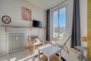 uma sala de estar com uma mesa e cadeiras e uma janela em IMMOGROOM - Bourgeois building - Quiet - Parking - Sea view em Cannes