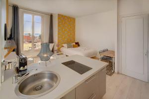 uma cozinha com um lavatório e uma sala de estar em IMMOGROOM - Bourgeois building - Quiet - Parking - Sea view em Cannes
