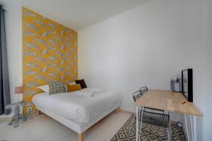 um quarto com uma cama com uma parede amarela em IMMOGROOM - Bourgeois building - Quiet - Parking - Sea view em Cannes