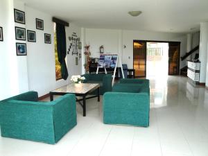sala de estar con sillas verdes y mesa en Harmony Hotel en Panglao City