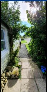 a stone path next to a house with a person walking down it at Barcloy Milk House in Kirkcudbright