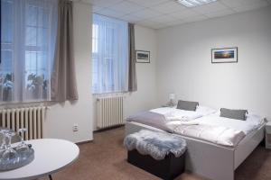 a white room with a bed and a table at CLASSIC apartmány Třinec in Třinec