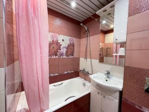 ホスタにあるStudio Kiparisovayaのピンクのシャワーカーテンとシンク付きのバスルーム