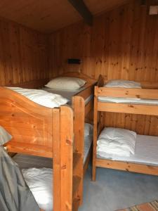 a room with three bunk beds in a cabin at Björsjöås Vildmark - Small camping cabin close to nature in Olofstorp