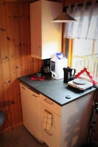uma cozinha com uma bancada com um micro-ondas e uma bancada em Björsjöås Vildmark - Small camping cabin close to nature em Olofstorp