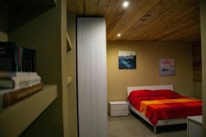 a bedroom with a bed with a red and orange blanket at LOFT nelle Valli in Pessinetto