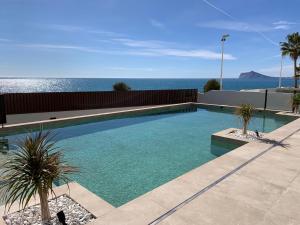 una piscina con el océano en el fondo en Apartamentos Maren en Calpe