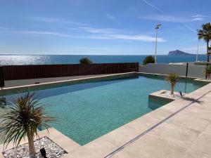 a swimming pool with the ocean in the background at Apartamentos Maren in Calpe