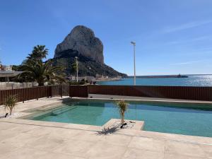 a swimming pool with a mountain in the background at Apartamentos Maren in Calpe