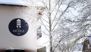 a tree covered in snow next to a building at die MÜHLE #10 in Reichenfels