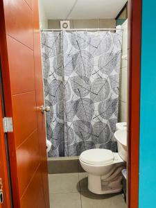 a bathroom with a toilet and a shower curtain at Sunset Hostel Airport in Lima
