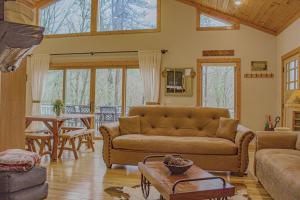 ein Wohnzimmer mit einem Sofa und einem Tisch in der Unterkunft Red Cedar Cabin in Franklin