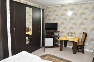 1 dormitorio con 1 cama y 1 mesa con TV en Hotel GeAS IV, en Caransebeş