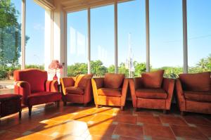 台東市的住宿－陽光滿屋民宿，一间设有橙色椅子和窗户的等候室