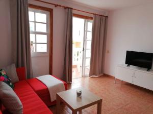 Una sala de estar con un sofá y un televisor. en David`s House, en Puerto Naos