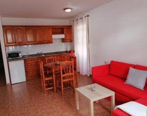 Una sala de estar con un sofá rojo y una mesa. en David`s House, en Puerto Naos