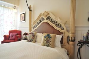 a bedroom with a bed and a red chair at Full Sun House - Peng's Family in Taitung City +19 photos