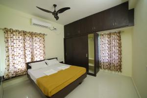 een slaapkamer met een bed en een plafondventilator bij Taj homes stay in Tirupati