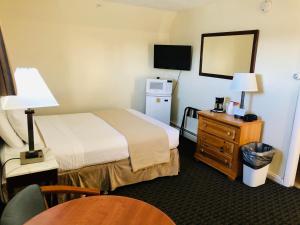 ein Hotelzimmer mit einem Bett, einem Tisch und einem Spiegel in der Unterkunft Sea Cliff House Motel in Old Orchard Beach