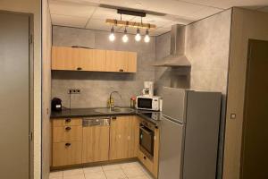 eine Küche mit einem Kühlschrank und einer Mikrowelle in der Unterkunft Le refuge des marmottes in Chamrousse
