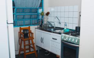 uma cozinha com um lavatório e um fogão forno superior em Céu do Mato - Hospedagem Domiciliar em Dourados