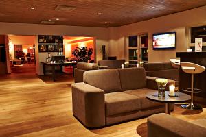 uma sala de estar com um sofá e uma televisão em Hotel Hedemarken em Grindsted