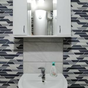 a bathroom sink with a white cabinet above it at Apartman Bambi Zlatar in Nova Varoš