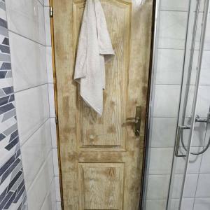 Una puerta de madera en un baño con una toalla. en Apartman Bambi Zlatar en Nova Varoš