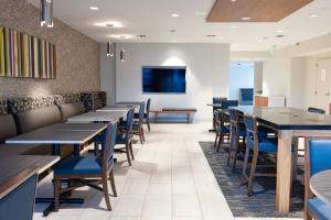 a dining room with tables and chairs and a flat screen tv at Holiday Inn Express Mill Valley San Francisco Area by IHG in Mill Valley
