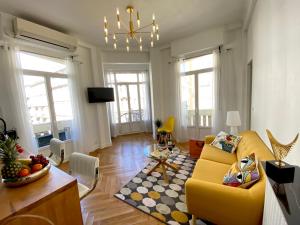 a living room with a yellow couch and a table at 2 Bedroom - Hyper Center - Kitchen - Tramway - Balcony - Air Conditioner - Wifi in Nice