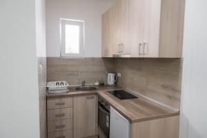 a kitchen with wooden cabinets and a sink at APARTMAN TEA in Belgrade