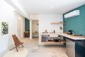 a kitchen with a counter and a chair in a room at Casa Neem in Cancún