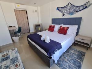 a bedroom with a large bed with red pillows at Hotel Carolina Del Mar in Santa Marta