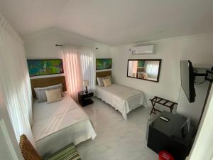 a hotel room with two beds and a television at Red Ground Village in San Andrés