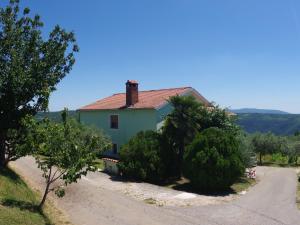 Gorica的住宿－Spacious apartment with views of the vineyards，路前有树木的蓝色房子